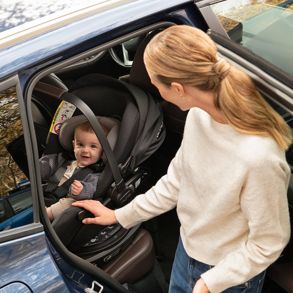 Black and gray Nuna ARRA Flex car seat with flat recline i-Size baby seat holding infant safely in harness
