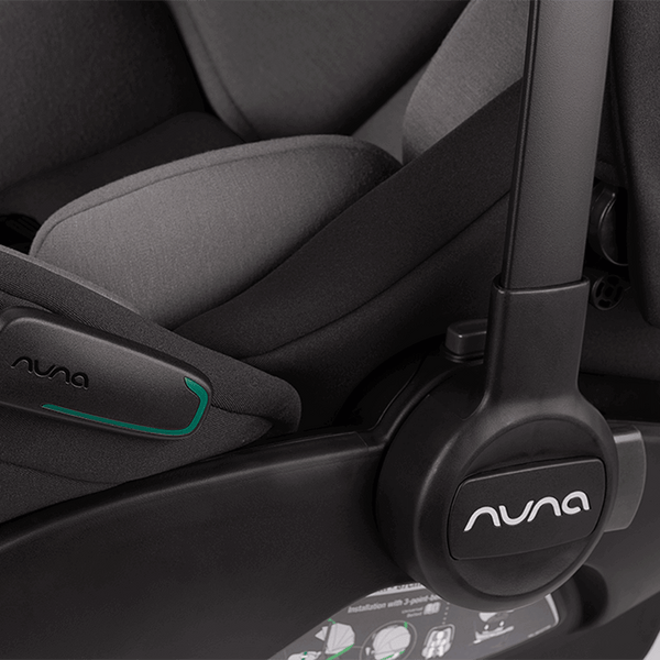 Black nuna arra flex infant car seat with gray fabric upholstery and teal accent line for flat recline i-size use