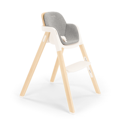 Modern Nuna BRYN highchair with a wooden frame, gray upholstered seat, and white plastic base for versatile use