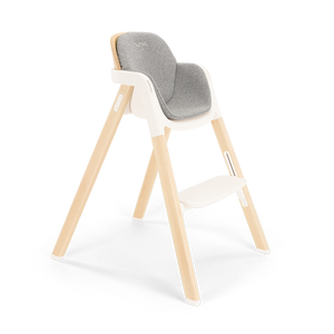 Modern wooden nuna bryn highchair with gray upholstered seat and white plastic frame in heritage bundle set