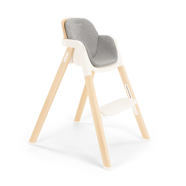 Modern wooden nuna bryn highchair with gray upholstered seat and white plastic frame for comfortable feeding