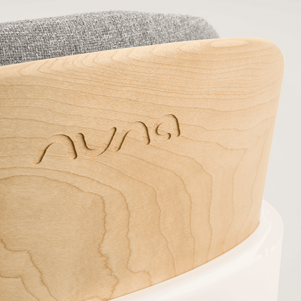 Light-colored wooden frame with subtle grain and auna engraving on the back of nuna bryn highchair heritage model
