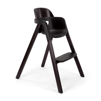 Dark brown wooden Nuna BRYN highchair with sleek modern design and integrated footrest for comfortable seating