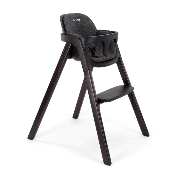 Black Nuna BRYN highchair with textured fabric seat and sleek wooden legs for stylish dining comfort