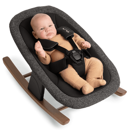 Gray textured fabric Nuna BRYN newborn rocker with wooden rockers and black safety harness in sanderson style