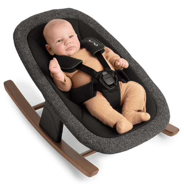 Gray textured fabric Nuna BRYN newborn rocker with wooden rockers and black safety harness in sanderson style