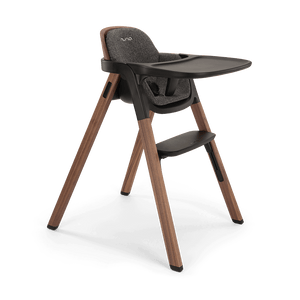 Modern wooden-legged Nuna BRYN highchair with dark gray upholstered seat and tray in Sanderson finish