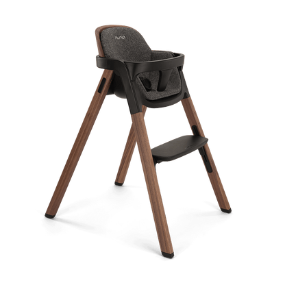 Modern wooden nuna bryn highchair with dark gray upholstered seat and backrest and black plastic accents in sanderson