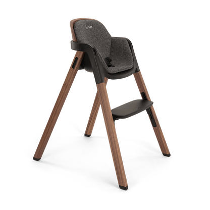 Modern wooden nuna bryn highchair with gray textured fabric seat black accents and nuna logo in sanderson finish