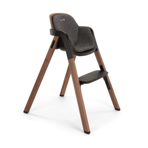 Nuna BRYN highchair featuring a modern wooden frame with dark gray upholstered seat and black plastic accents