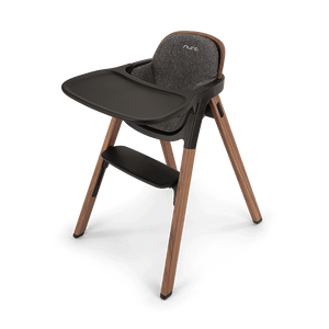 Modern nuna bryn highchair with wooden legs dark gray fabric seat and black tray for toddler dining use