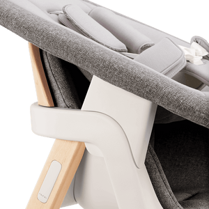 Nuna BRYN newborn rocker in gray textured fabric with light wood frame and white plastic accents for infant comfort