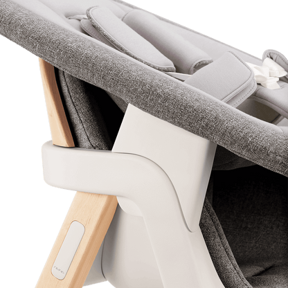 Nuna BRYN newborn rocker in gray textured fabric with light wood frame and white plastic accents for infant comfort