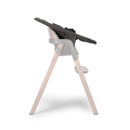 Modern high chair with dark gray textured fabric seat supported by wooden legs and black plastic joints Nuna BRYN newborn rocker