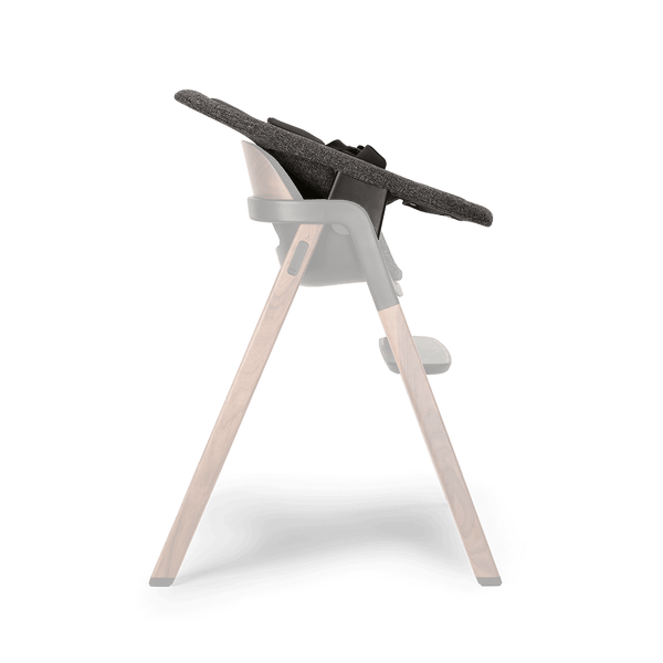 Modern high chair with dark gray textured fabric seat supported by wooden legs and black plastic joints Nuna BRYN newborn rocker