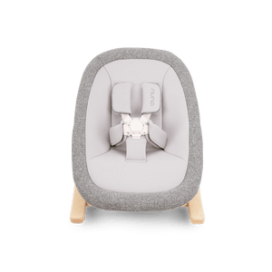 Gray and white fabric nuna bRYN newborn rocker with wooden legs designed for infant comfort and soothing motion