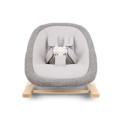 Nuna bryn newborn rocker with gray textured fabric, light wood base, and white safety harness for infants