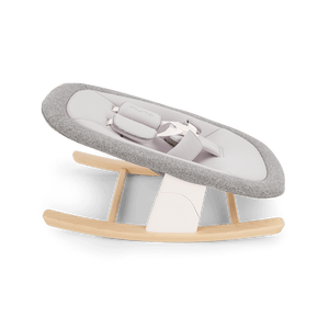 Gray and white fabric baby rocker with wooden rockers in nuna bryn highchair and newborn rocker bundle heritage