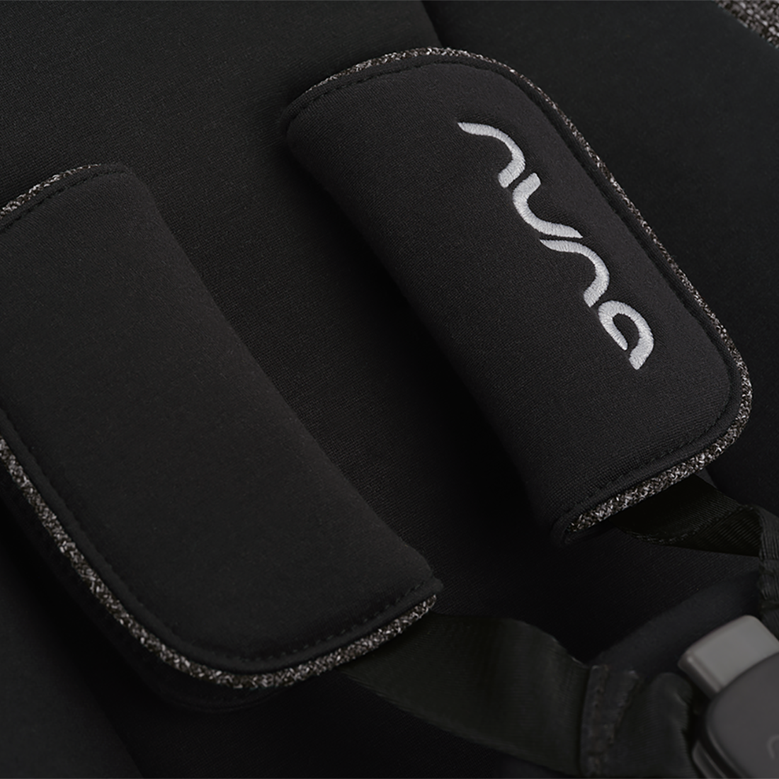 Black neoprene padded shoulder strap with silver embroidered Nuna logo and textured edge trim for Nuna BRYN newborn rocker