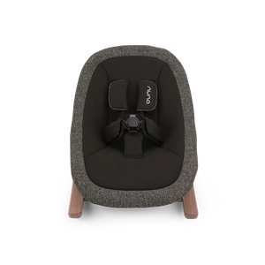 A modern nuna bryn newborn rocker baby bouncer with textured charcoal gray fabric and light wood legs