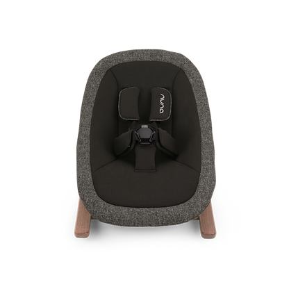 A modern nuna bryn newborn rocker baby bouncer with textured charcoal gray fabric and light wood legs