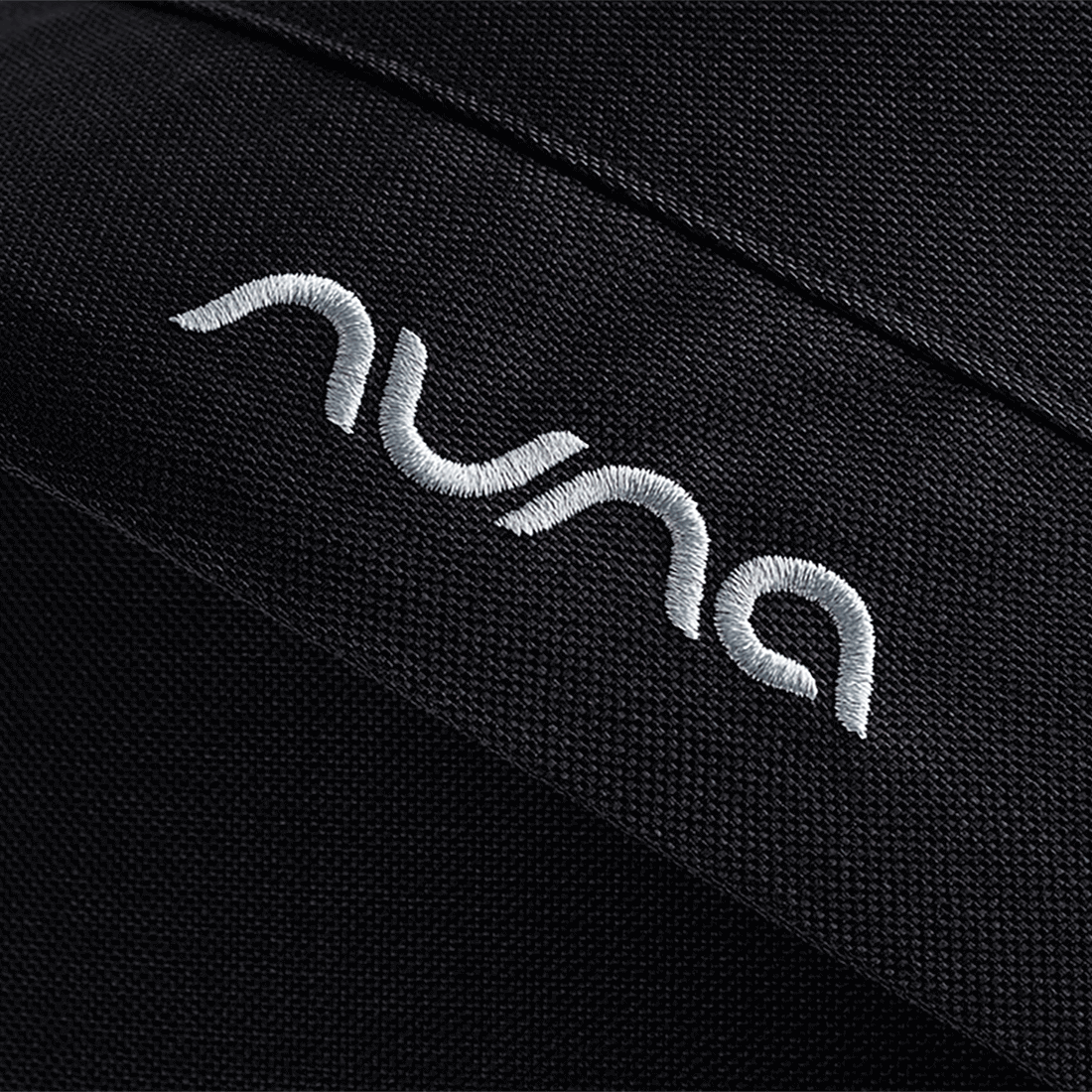 Black textured fabric with white embroidered nuna logo on caviar nuna mixx next stroller seat material