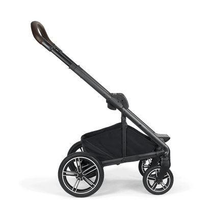 Black Nuna MIXX NEXT stroller with sleek frame brown leather handle and silver accented wheels shown from the back side