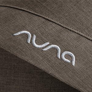 White embroidered nuna logo on textured olive green fabric of nuna mixx next stroller pistachio seat