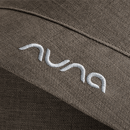 White embroidered nuna logo on textured olive green fabric of nuna mixx next stroller pistachio seat