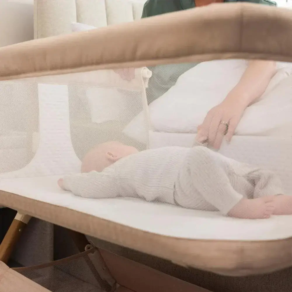 OBaby Cloud Bedside Crib Bundle Including Fitted Sheets – Oatmeal with a baby resting comfortably.