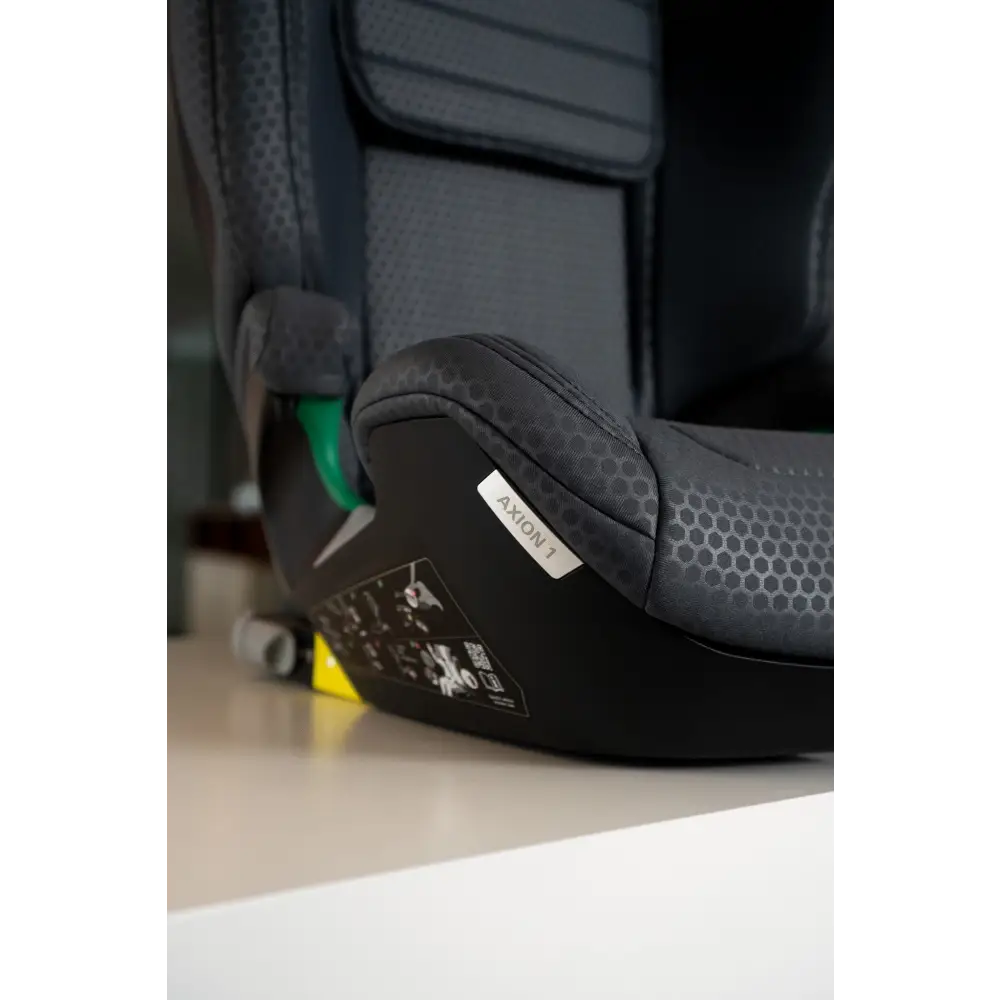 Close-up of the Gallant Grey seat cushion and black base, showing the AXION 1 label and green lap belt guide.