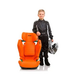 Child in a black racing suit holding a helmet beside the Vibrant Orange Recaro AXION 1.