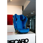 Recaro AXION 1 in Calm Blue on a white Recaro display stand, showing the padded seat and headrest.