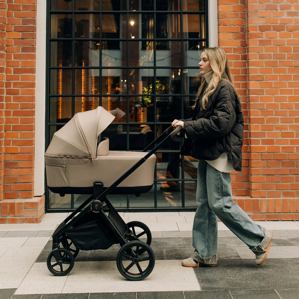 Beige and black modern stroller with a sleek, minimalist design.